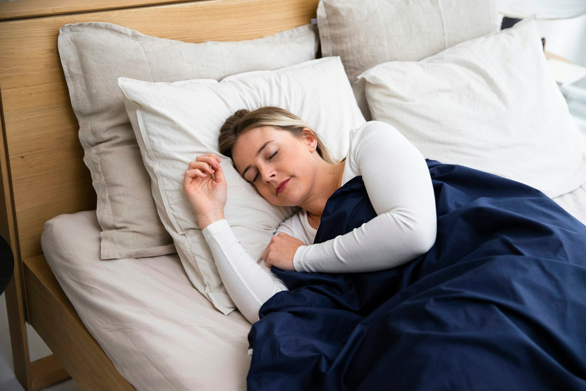Vrouw diep in slaap met blauwe deken — Ralune 100% natuurlijk